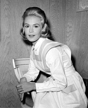 Actress Sandra Dee, portraying a nurse's helper in the motion picture production