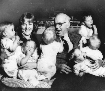 Dr. Benjamin Spock is shown visiting Karen Anderson, the mother of quintuplets with their sibling, in October 1974. (AP Photo)